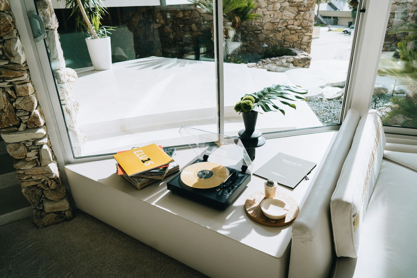 a table with a record player and a plant on it